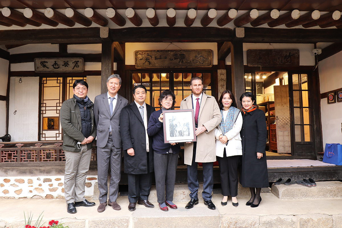 Csoma Mózes nagykövet Li The Dzsun író egykori lakóházánál átadja az MTI archívumból származó fényképet az író leszármazottainak - fotó